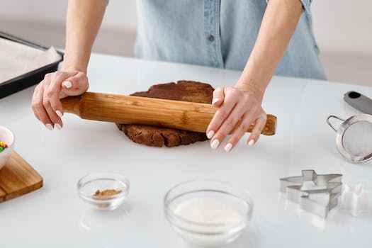 Person Flattening a Chocolate Dough With Rolling Pin