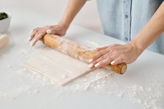 Person Flattening a Dough With Rolling Pin