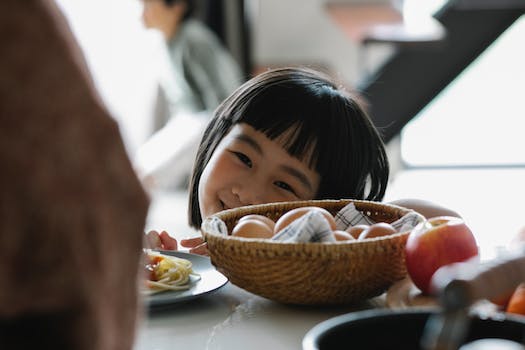Happy Asian little girl in kitchen
