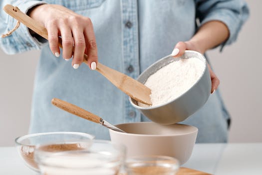 Person Adding Flour into a Bowl