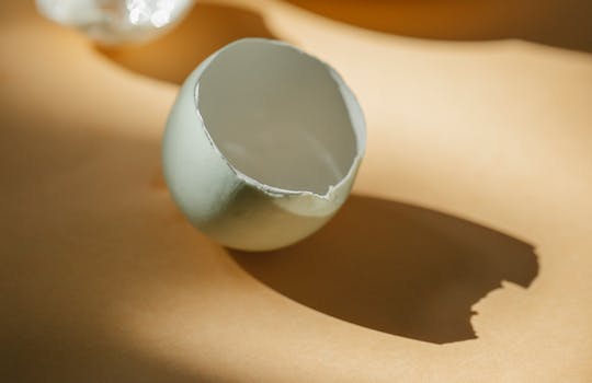 White eggshell placed on table in kitchen in sunny morning