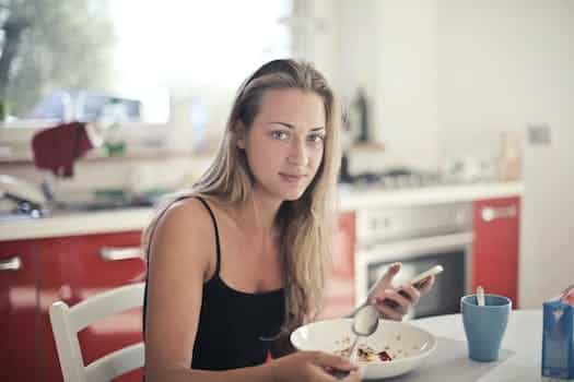 Woman in Black Tank Top Eating Oatmeal