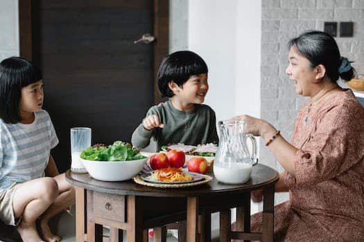 Asian woman having breakfast with cute children