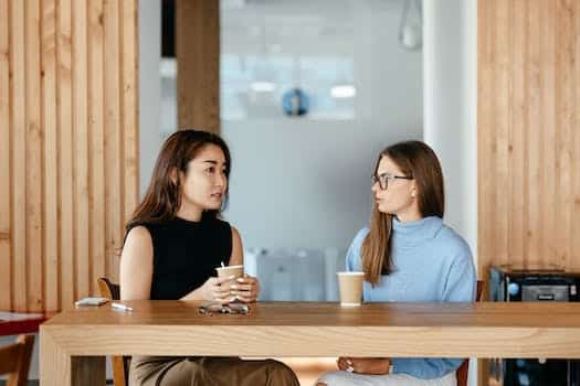 Diverse women talking during coffee break at table