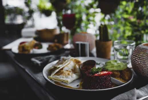 Plate with delicious red rice served with roti bread and avocado against stylish interior of tropical cafe