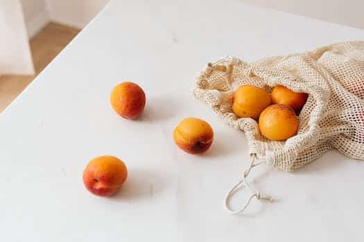 Organic sweet apricots in cotton sack placed on table
