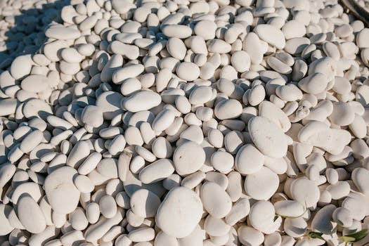 From above of white small smooth and round stones in pile at sunshine